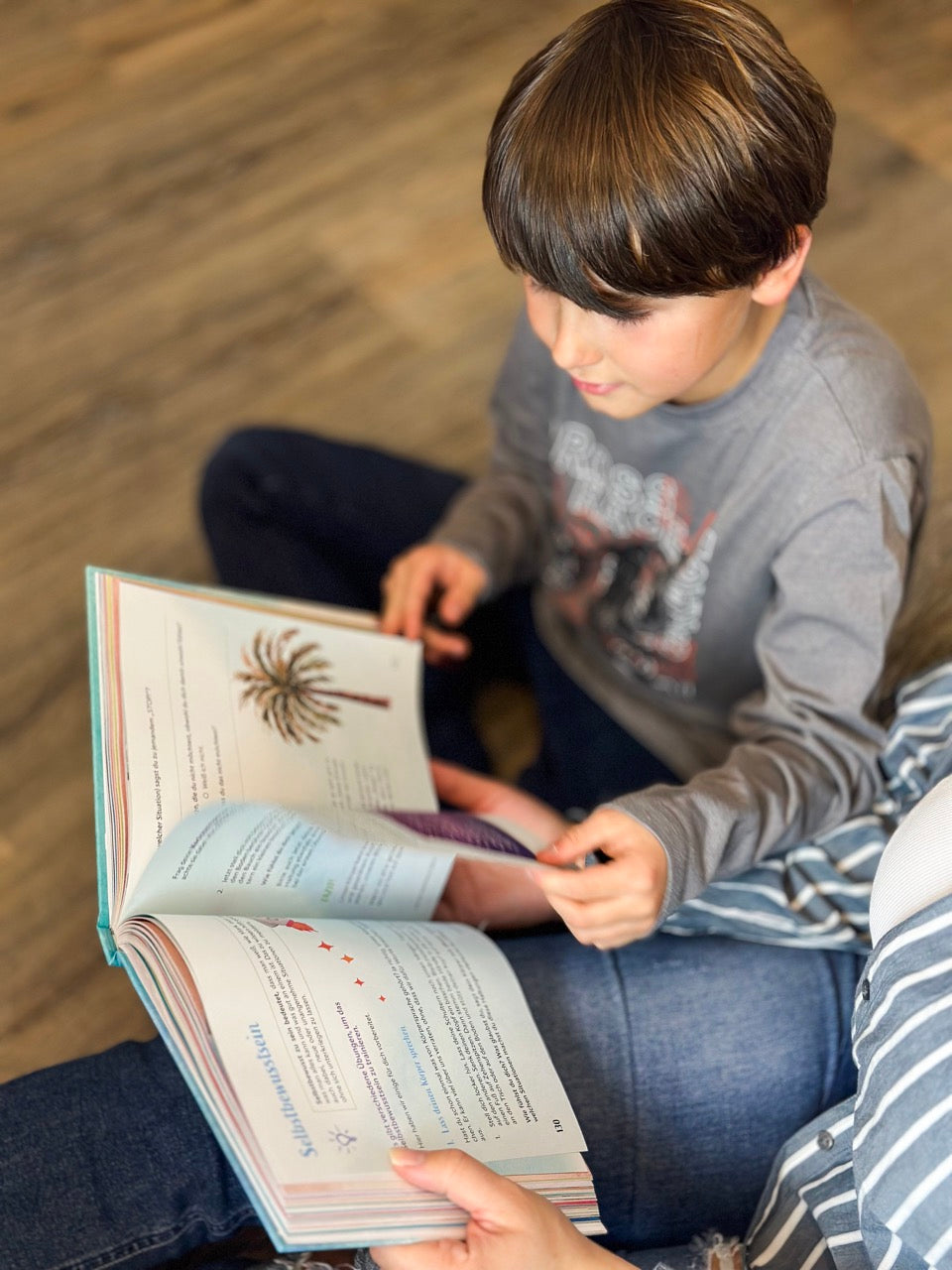 Lesemoment mit "Unsere Zukunftshelden": Ein Kind liest das interaktive Buch gemeinsam mit seiner Bezugsperson und tauscht sich aus.