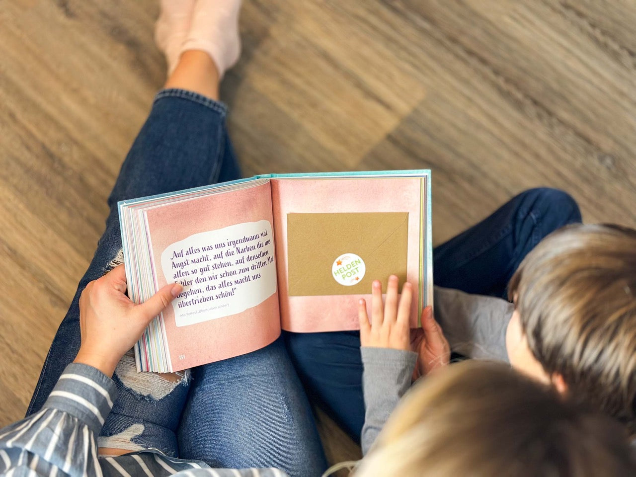 Interaktives Lernen mit der Zukunftshelden Ausbildung: Ein Kind wird von einer Bezugsperson begleitet. Text-Overlay: Wir spenden Bücher nach jedem 1.000sten Verkauf an Einrichtungen, die Kinder unterstützen, da nicht jedes Kind die gleichen Chancen hat.